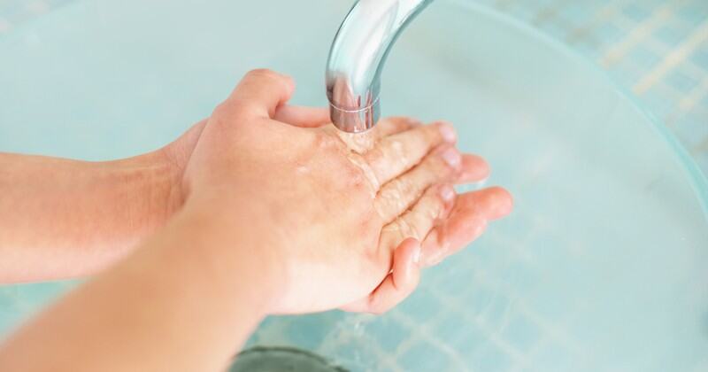 hands being washed under a faucet